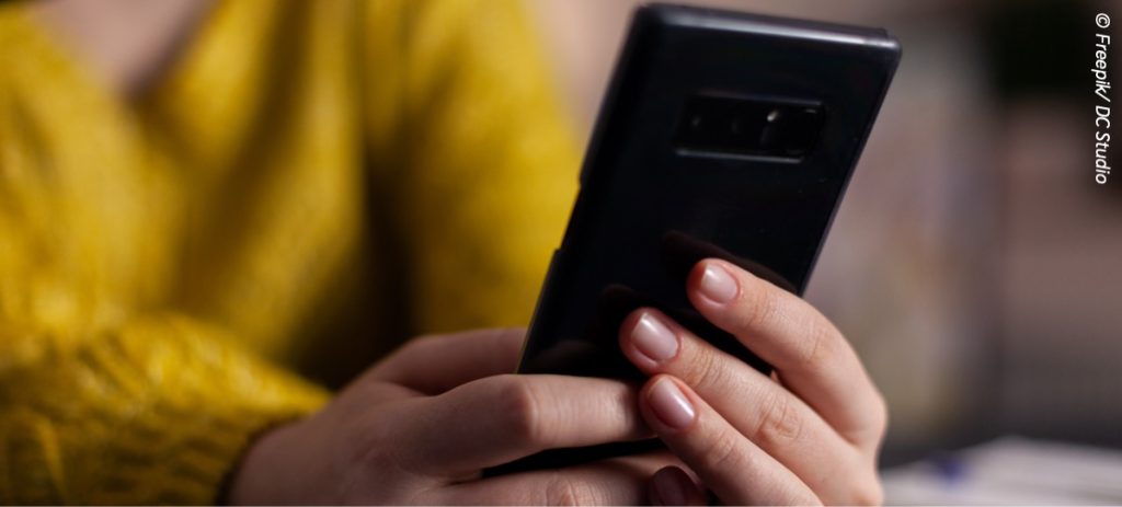 closeup-social-media-vlogger-with-headset-holding-smartphone-reading-questions-answering-using-production-microphone-sitting-desk-podcasting-studio-home-air-show